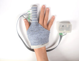 Un gant tricoté masse la main pour traiter l'œdème