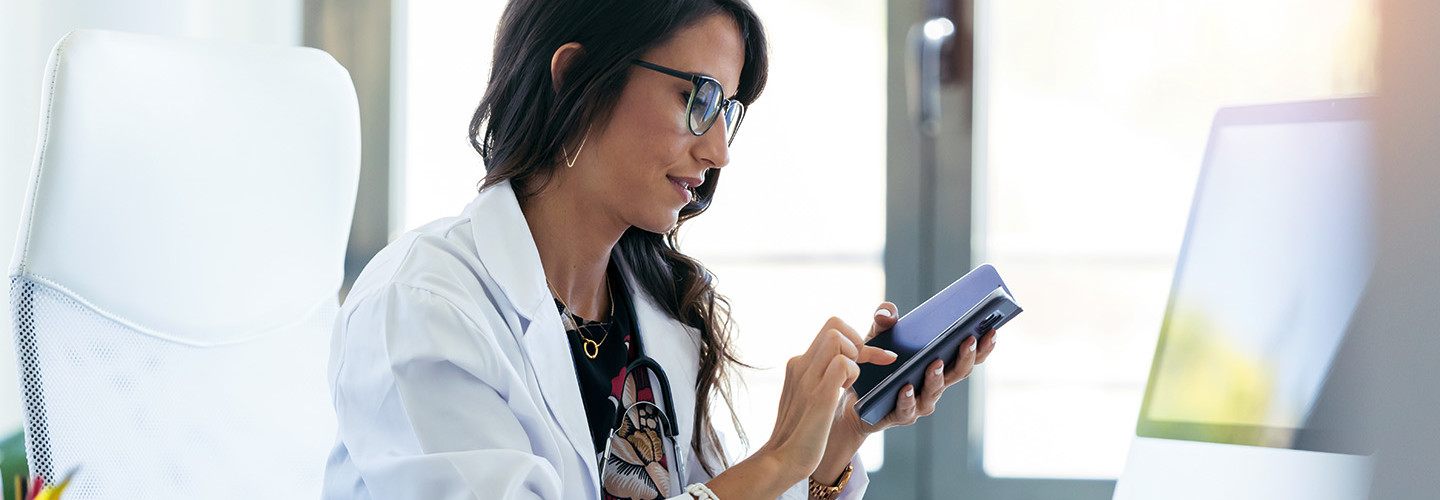 doctor texts on cell phone in office