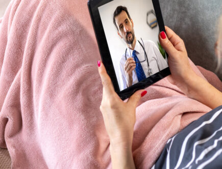 Mature woman using digital tablet for conversation with her doctor.